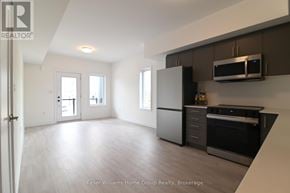 Guelph (Pineridge/Westminster Woods) townhouse for rent - A spacious kitchen with a refrigerator, microwave, and oven.