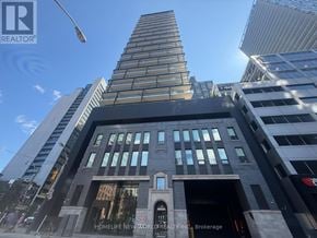 Toronto (Waterfront Communities) condo for rent - A tall building with a sign that says "HOMELIFE NEW WORLD REALTY INC. Brokerage" on the front.