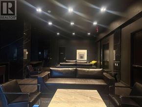 Toronto (Waterfront Communities) condo for rent - A modern living room with a large sectional sofa and a coffee table.