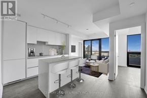 Mississauga (City Centre) condo for rent - A modern kitchen with white cabinets and a bar area.