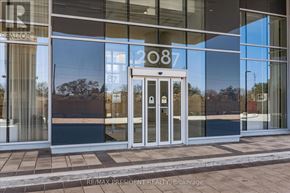 Burlington (Freeman) condo for rent - The image shows the front of a building with a glass facade and a door with a number 2087 on it.