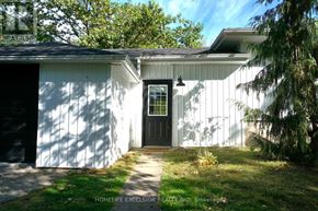 Ramara apartment for rent - A white house with a black door and a small porch.