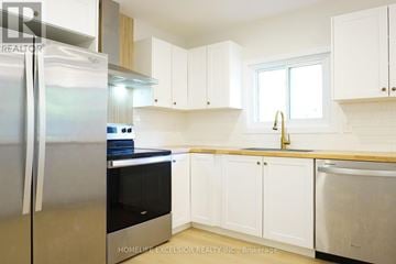Ramara apartment for rent - A kitchen with white cabinets and a stainless steel refrigerator.