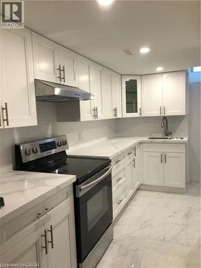 Hamilton apartment for rent - A kitchen with white cabinets and marble countertops.