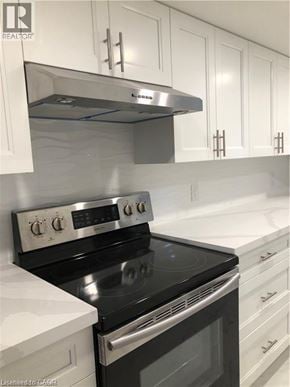 Hamilton apartment for rent - A modern kitchen with a stove top oven and white cabinets.