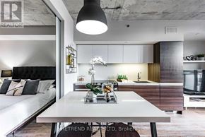 Toronto (Little Portugal) condo for rent - A modern kitchen with a dining table in the middle.