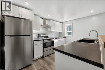 Brantford apartment for rent - A modern kitchen with a stainless steel refrigerator and black countertops.