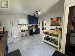 Copper Cliff apartment for rent - A kitchen with a refrigerator, sink, and a counter with a pot on it.