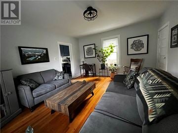 Copper Cliff apartment for rent - A living room with a grey couch, a wooden coffee table, and a painting on the wall.