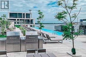 Toronto (Waterfront Communities) condo for rent - A modern outdoor area with a grill, lounge chairs, and a pool.
