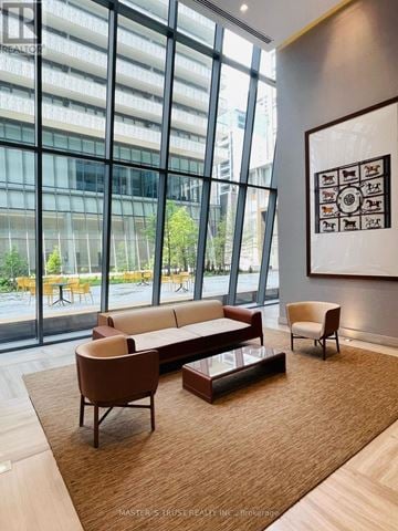 Toronto (Church-Yonge Corridor) condo for rent - A living room with a couch, chair, and coffee table with a large window in the background.