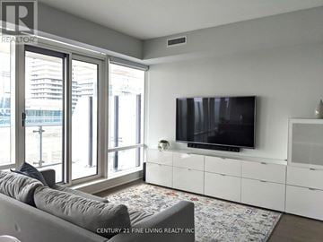 Toronto (Church-Yonge Corridor) condo for rent - A living room with a grey couch and a flat screen TV mounted on the wall.