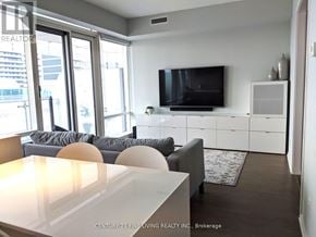 Toronto (Church-Yonge Corridor) condo for rent - A living room with a grey couch and a television on the wall.