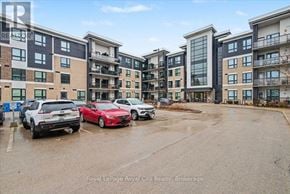 Guelph (Kortright East) condo for rent - A parking lot with cars and apartment buildings in the background.