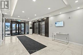 Guelph (Kortright East) condo for rent - A white hallway with a black carpet leading to a glass door.