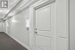 Guelph (Kortright East) condo for rent - A hallway with a door and lights on the wall.
