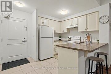 Guelph (Kortright East) condo for rent - A kitchen with white cabinets and a white refrigerator.