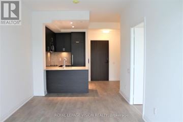 Toronto (Annex) condo for rent - A modern kitchen with black cabinets and a wooden floor.