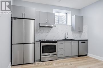Toronto (Tam O'shanter-Sullivan) apartment for rent - A modern kitchen with stainless steel appliances and marble countertops.