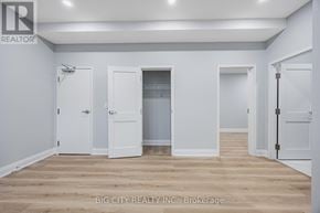 Toronto (Tam O'shanter-Sullivan) apartment for rent - A room with white walls and wooden flooring, with four doors, one of which is open.