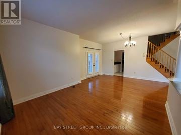 Richmond Hill (Jefferson) apartment for rent - A spacious room with wooden floors and a staircase on the right side.