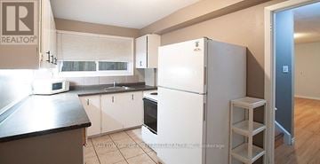 London North (North N) fourplex for rent - A kitchen with a refrigerator, microwave, and oven.