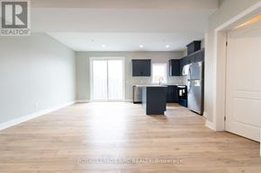 St. Catharines (Oakdale) townhouse for rent - A spacious kitchen with wooden flooring and modern appliances.