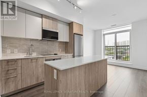 Toronto (Regent Park) condo for rent - A modern kitchen with wooden cabinets and a large island.