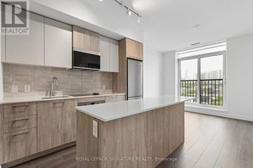 Toronto (Regent Park) condo for rent - A modern kitchen with wooden cabinets and a large island.