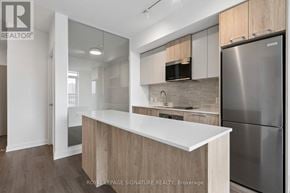 Toronto (Regent Park) condo for rent - A modern kitchen with a white countertop and stainless steel appliances.
