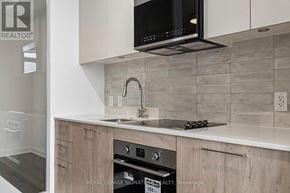 Toronto (Regent Park) condo for rent - A modern kitchen with a microwave oven mounted above the stove.