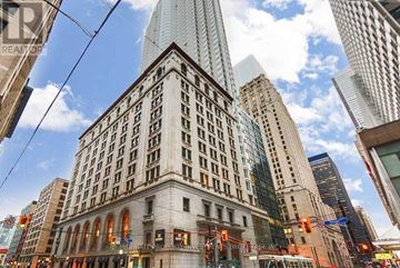 Toronto (Bay Street Corridor) condo for rent - A tall building with a sign that says "Theatre Royal" is in the middle of a city.