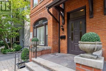 Toronto (Annex) triplex for rent - A brick house with a dark brown door and a stone planter on the steps.