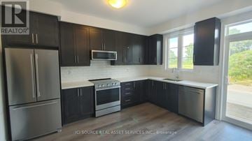 Brant (Paris) townhouse for rent - A kitchen with black cabinets and stainless steel appliances.