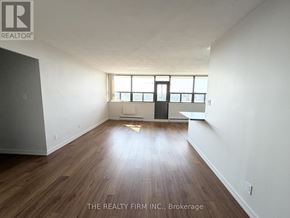 London East (East B) condo for rent - A room with wooden flooring and white walls, with a door and a window.