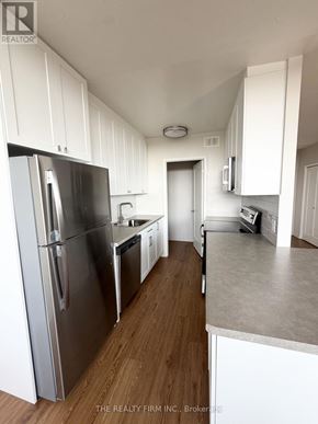 London East (East B) condo for rent - A kitchen with white cabinets and a stainless steel refrigerator.