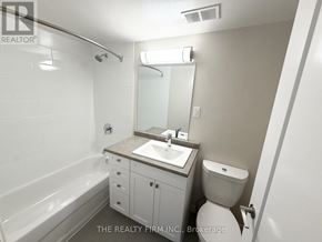 London East (East B) condo for rent - A white bathroom with a sink, toilet, and bathtub.