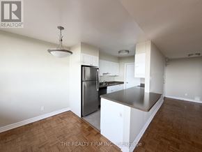 London East (East B) condo for rent - A kitchen with white cabinets and a wooden floor.