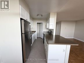 London East (East B) condo for rent - A kitchen with white cabinets and a stainless steel refrigerator.