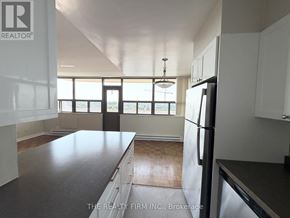 London East (East B) condo for rent - A kitchen with a black countertop and a refrigerator.