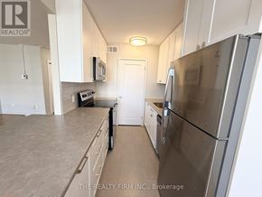 London East (East B) condo for rent - A kitchen with a refrigerator, microwave, and oven.
