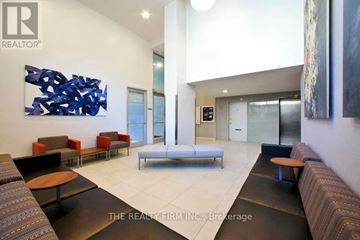 London East (East B) condo for rent - A modern living room with a large abstract blue painting on the wall.