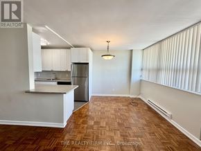 London East (East B) condo for rent - A kitchen with white cabinets and a wooden floor.