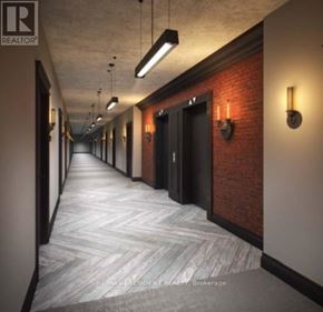 Toronto (Waterfront Communities) condo for rent - A long hallway with a brick wall and doors on the side.