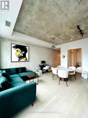 Toronto (Waterfront Communities) condo for rent - A living room with a green couch and a painting of a man with black hair.
