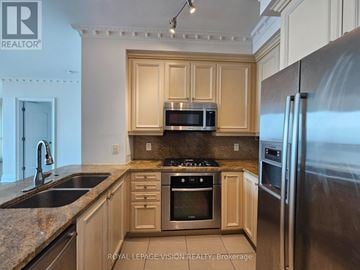 Toronto (Waterfront Communities) condo for rent - A kitchen with wooden cabinets and stainless steel appliances.