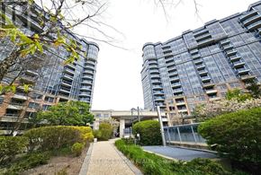 Markham (Unionville) condo for rent - A view of a residential area with two buildings, a bridge, and a garden.