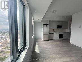 Vaughan (Concord) condo for rent - A spacious, well-lit kitchen and living room with a view of the cityscape outside the window.