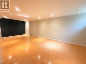 Oakville (Fa Falgarwood) house for rent - A room with wooden flooring and a logo of Bay Street Integrity Realty Inc. Brokerage on the wall.