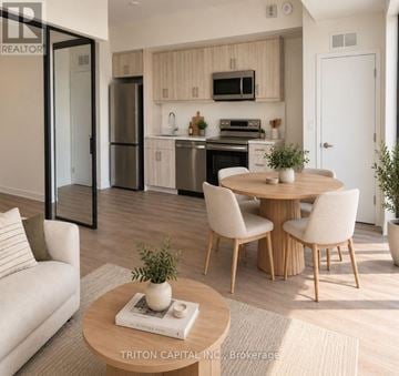 Welland (Broadway) condo for rent - A modern kitchen with a dining table set up with chairs.